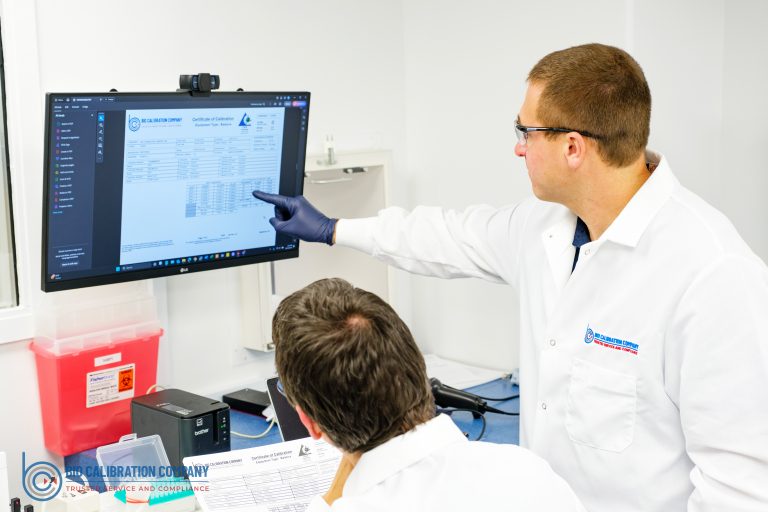 Laboratory personnel reviewing pipette calibration certificate results and calibration documentation